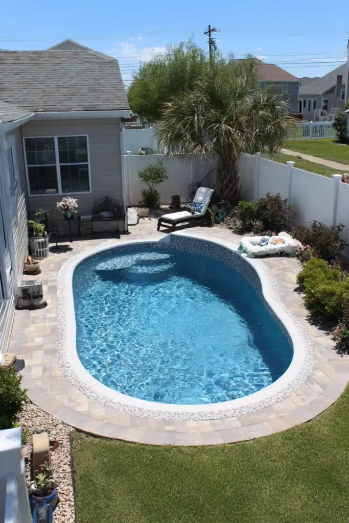 Large oval semi in-ground pool with tile liner and cobalt pool bottom in backyard