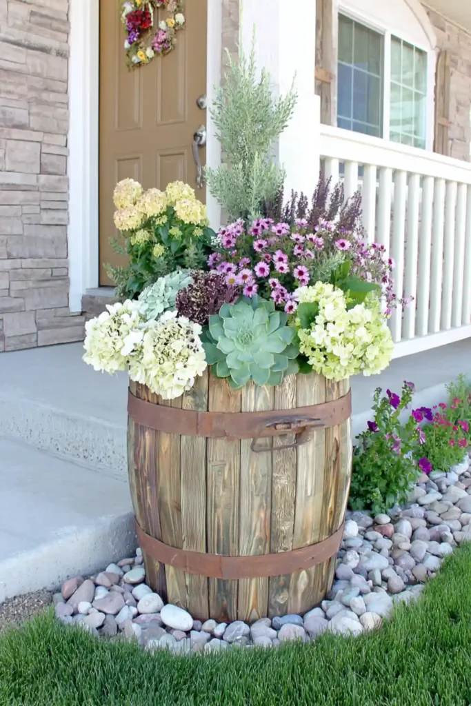 wooden barrel planter filled with flowers in a front yard