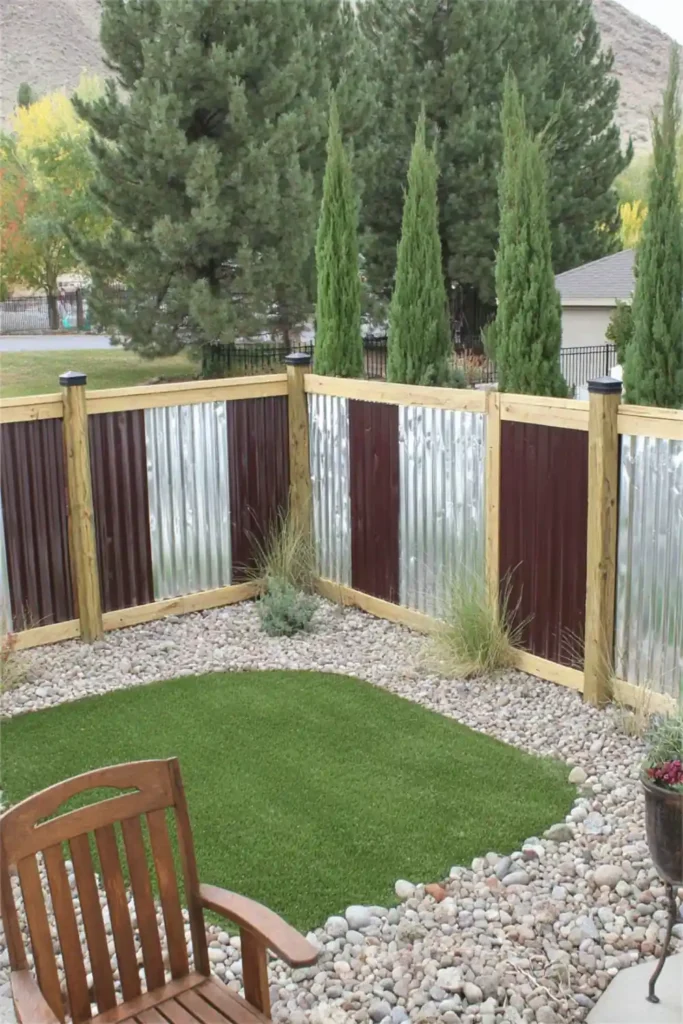 33 Privacy Fence Ideas That Make Your Yard Feel More Peaceful 2 Backyard with corrugated metal privacy fence panels framed in wood with cedar trees along the fence