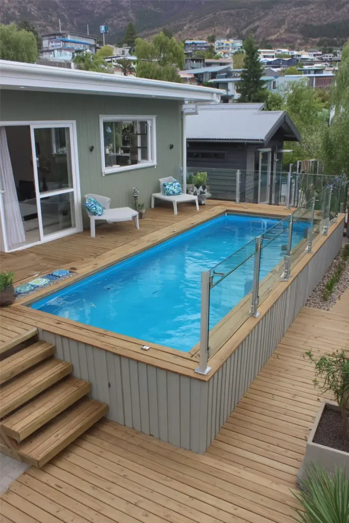 minimalist above ground pool with composite panels and glass railing in a modern backyard