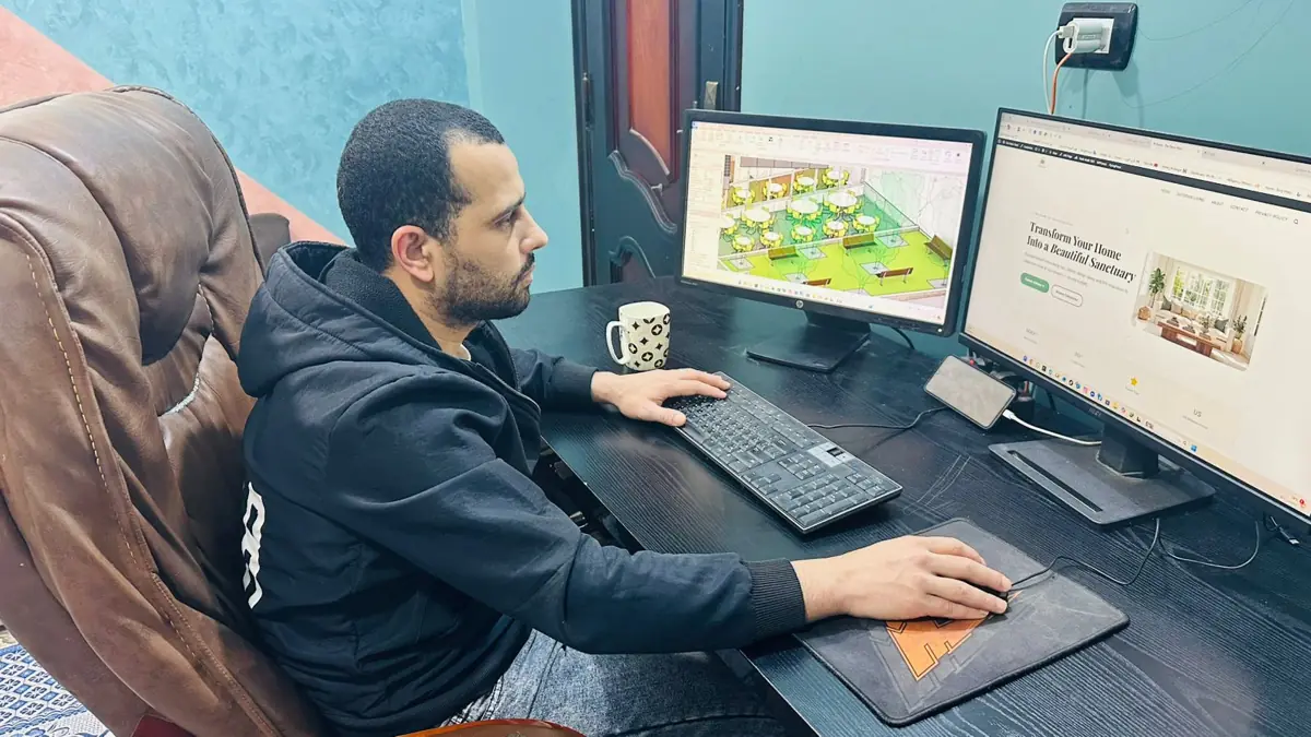 About 2 Mohammed working on home decor and interior design planning at his dual-monitor desk