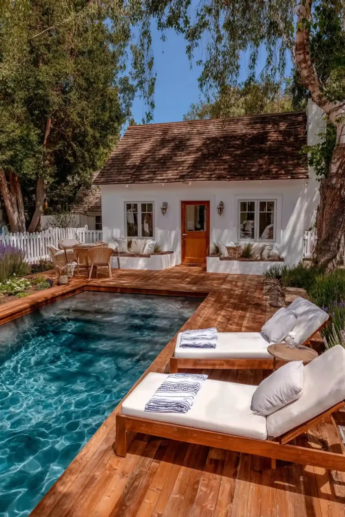 Wooden pool deck with chaise lounge chairs arranged for relaxing by the pool
