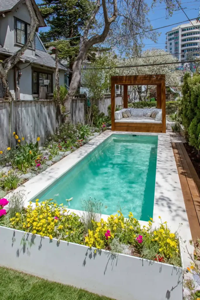 Above-ground pool surrounded by flower beds and evergreen shrubs
