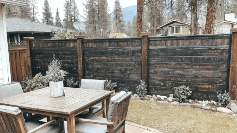 33 Privacy Fence Ideas That Make Your Yard Feel More Peaceful 8 Backyard showing multiple privacy fence ideas including wood fencing, hedges, and stone columns in a residential outdoor setting
