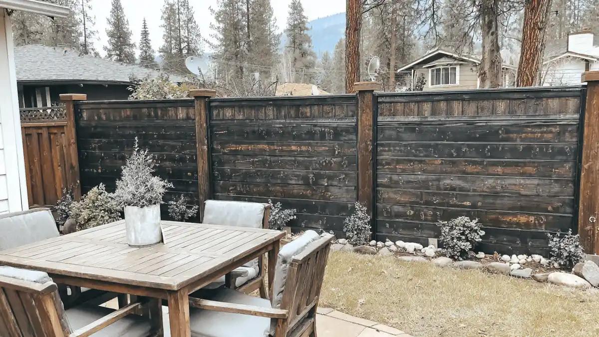 33 Privacy Fence Ideas That Make Your Yard Feel More Peaceful 1 Backyard showing multiple privacy fence ideas including wood fencing, hedges, and stone columns in a residential outdoor setting