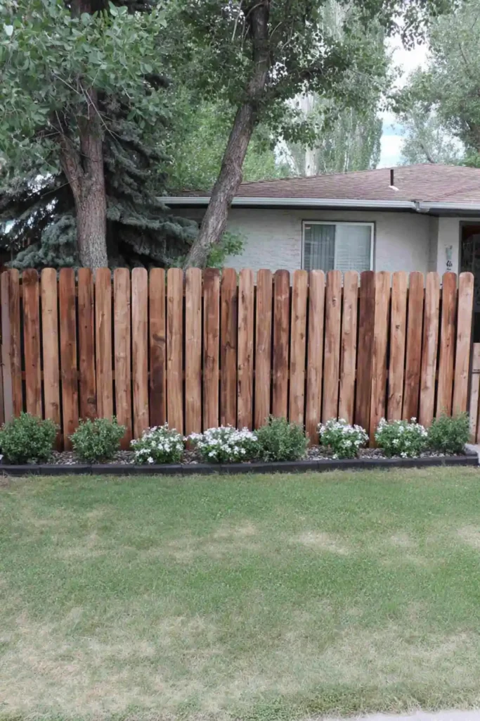 33 Privacy Fence Ideas That Make Your Yard Feel More Peaceful 3 Solid tongue and groove wood privacy fence with flower bed along the base in a backyard