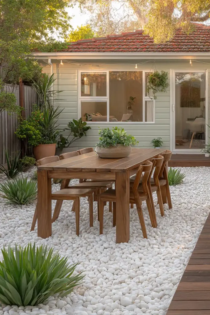White Stone Landscaping Ideas for a Clean, Modern Outdoor Space 16 Outdoor dining area with white gravel and wooden table