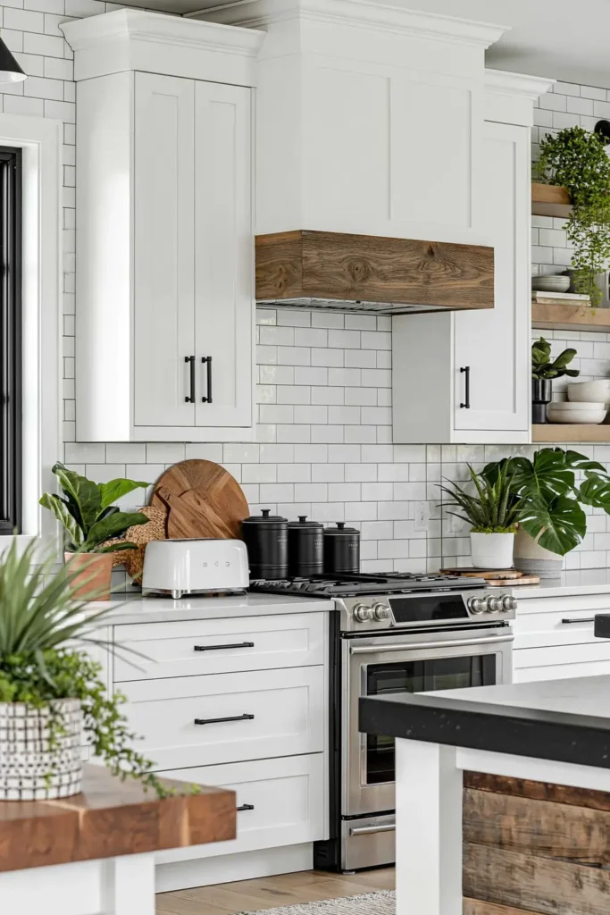 Black canisters on a bright white kitchen counter with subway tile, wood range hood accent, white toaster, plants, and wall shelves.