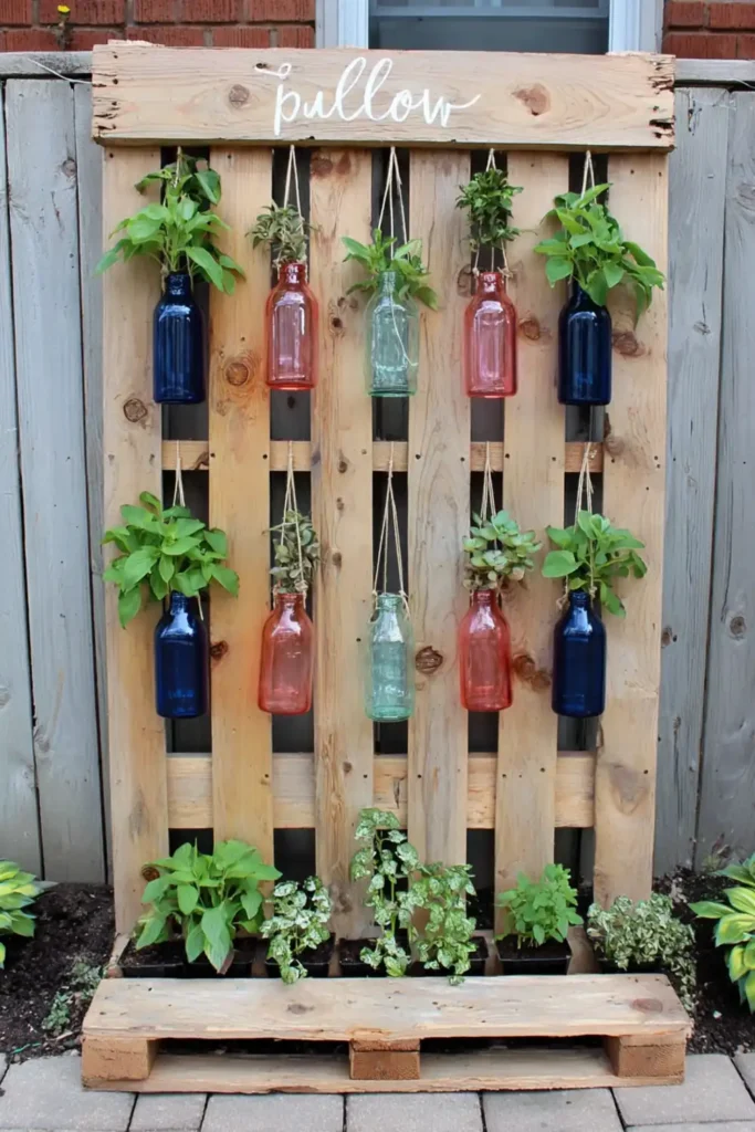 Recycled bottle vertical planters hanging in front of pallet slats with small green plants