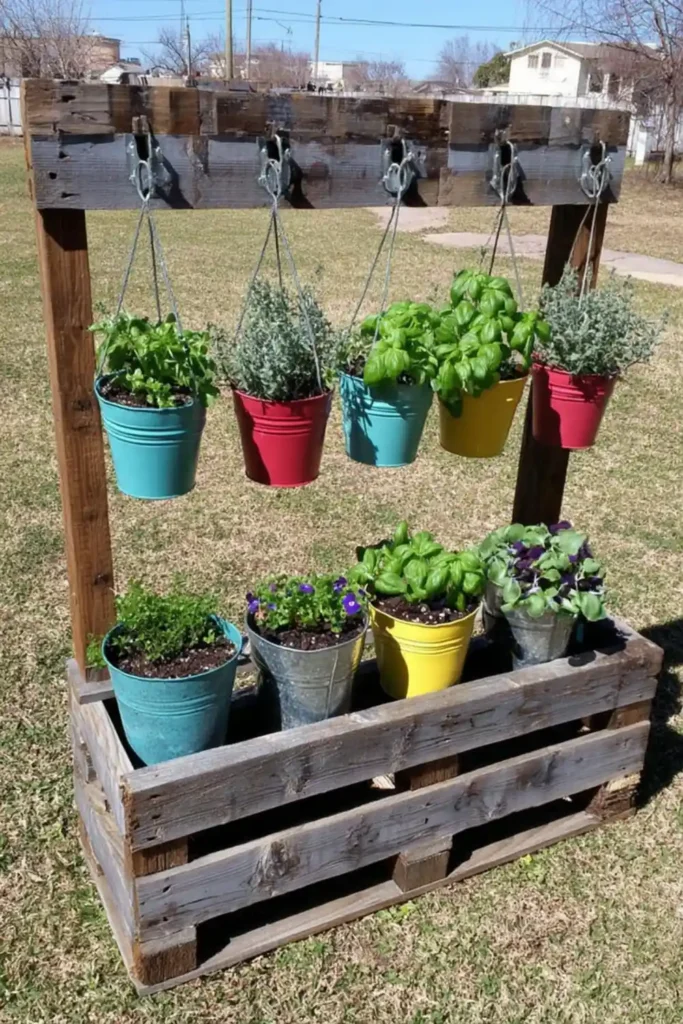 Rustic pallet garden with hanging metal bucket planters in a yard