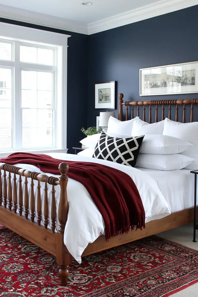 Guest bedroom with very dark navy walls, a wooden spindle bed, white bedding, and a red vintage-style rug.