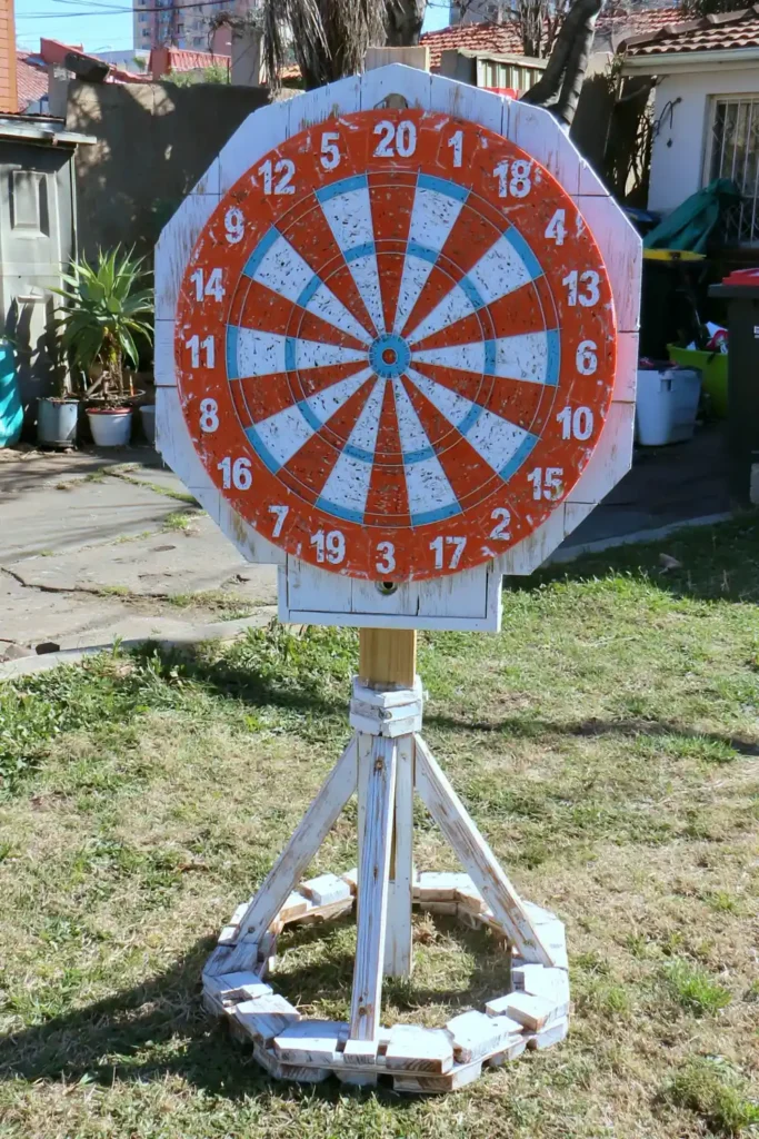 20 Budget-Friendly Outdoor Landscaping Ideas for a Charming Yard 7 Outdoor dart board setup with protective backing in a backyard garden.