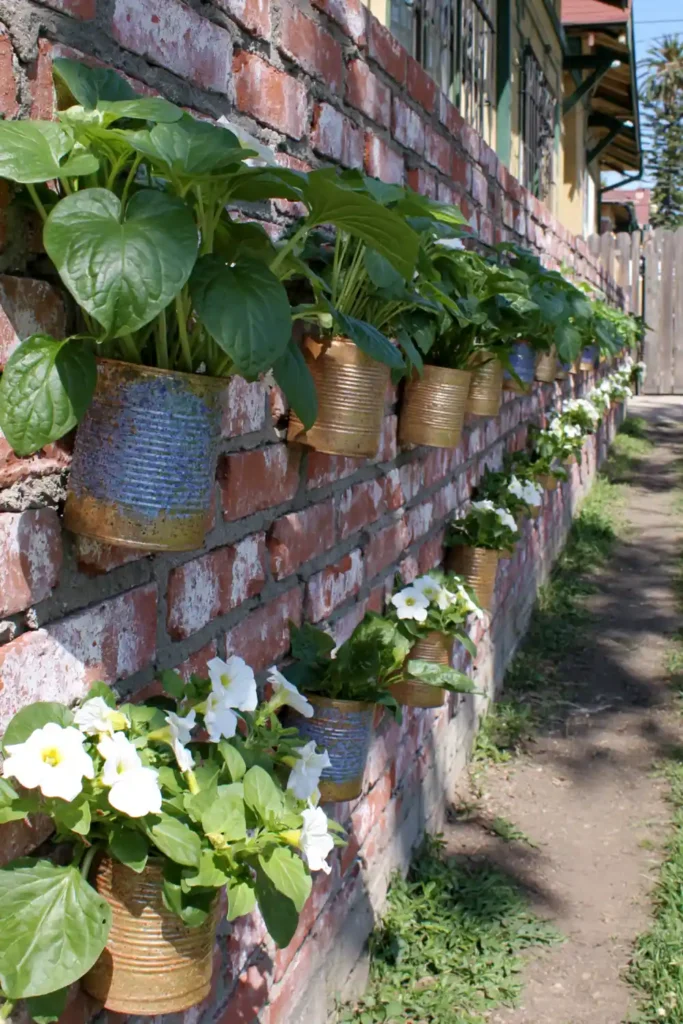 20 Budget-Friendly Outdoor Landscaping Ideas for a Charming Yard 13 Bright blue recycled tin can planters with greenery and white flowers on a red brick wall.
