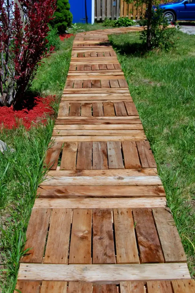 20 Budget-Friendly Outdoor Landscaping Ideas for a Charming Yard 19 Simple floating deck made from repurposed wood in a backyard garden.