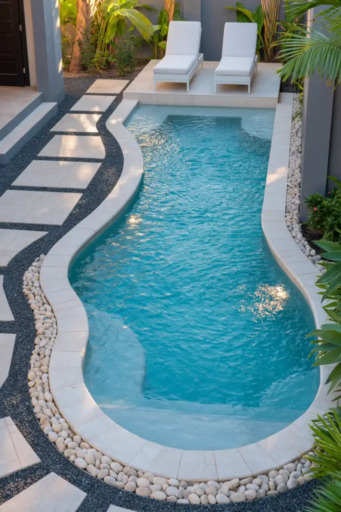 Small plunge pool with turquoise water, tanning ledge, white lounge chairs, pale coping, pavers, and tropical plants