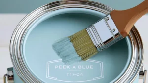 Open can of soft blue paint with a paintbrush for soft blue living room paint inspiration