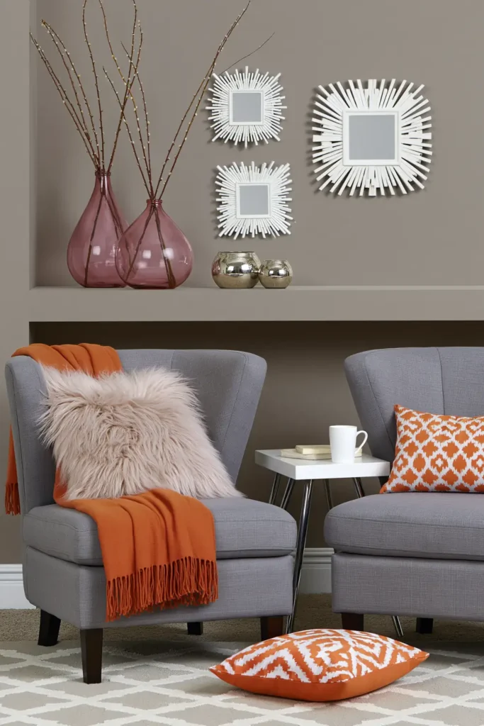 Trend Color Spotlight: Off the Grid Paint Inspiration for Warm, Modern Rooms 2 Warm beige-gray room with pumpkin orange accents, gray chairs, soft pillows, and cozy Off the Grid paint inspiration.