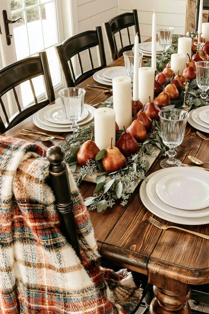 31 Fall Table Decor Ideas for Entertaining in a Warm, Seasonal Style 20 Neutral fall table arrangement with red pears, seeded eucalyptus, white pillar candles, clear goblets, and gold-toned flatware.