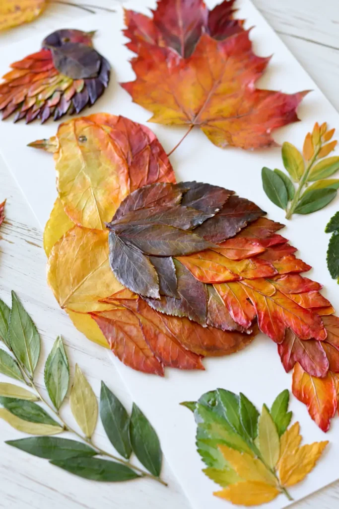 Pressed fall leaves arranged into playful animal and figure art on a white background.