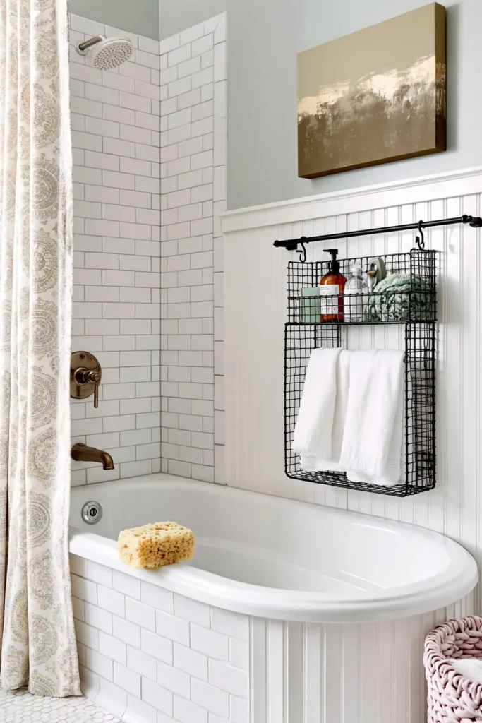 18 Small Bathroom Storage Ideas for a More Organized Space 2 Black wire bathroom organizer holding bath products and white towels beside a white subway-tile bathtub.