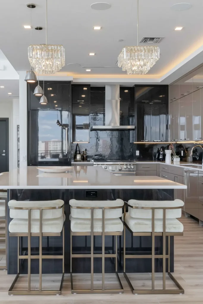 Black kitchen backsplash with charcoal cabinetry, a dark island, and pale green brass-framed stools.