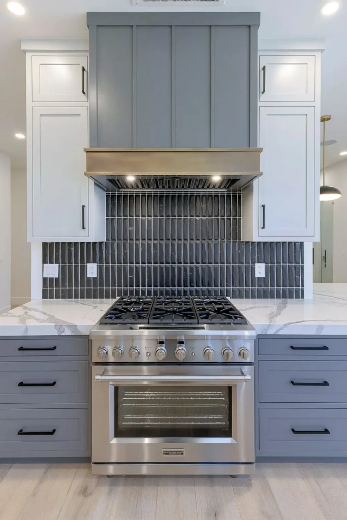 Raised charcoal 3D-patterned backsplash tile behind a stainless-steel range and metallic hood.