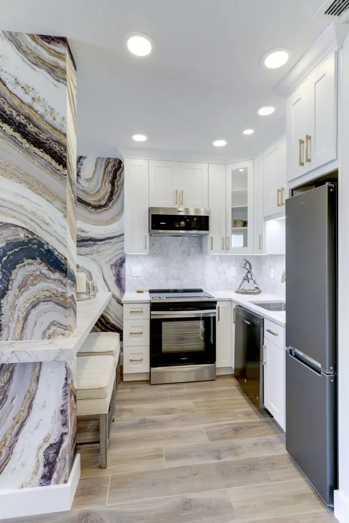Compact kitchen with a soft white backsplash and bold abstract wallpaper in blue, gray, beige, and white.