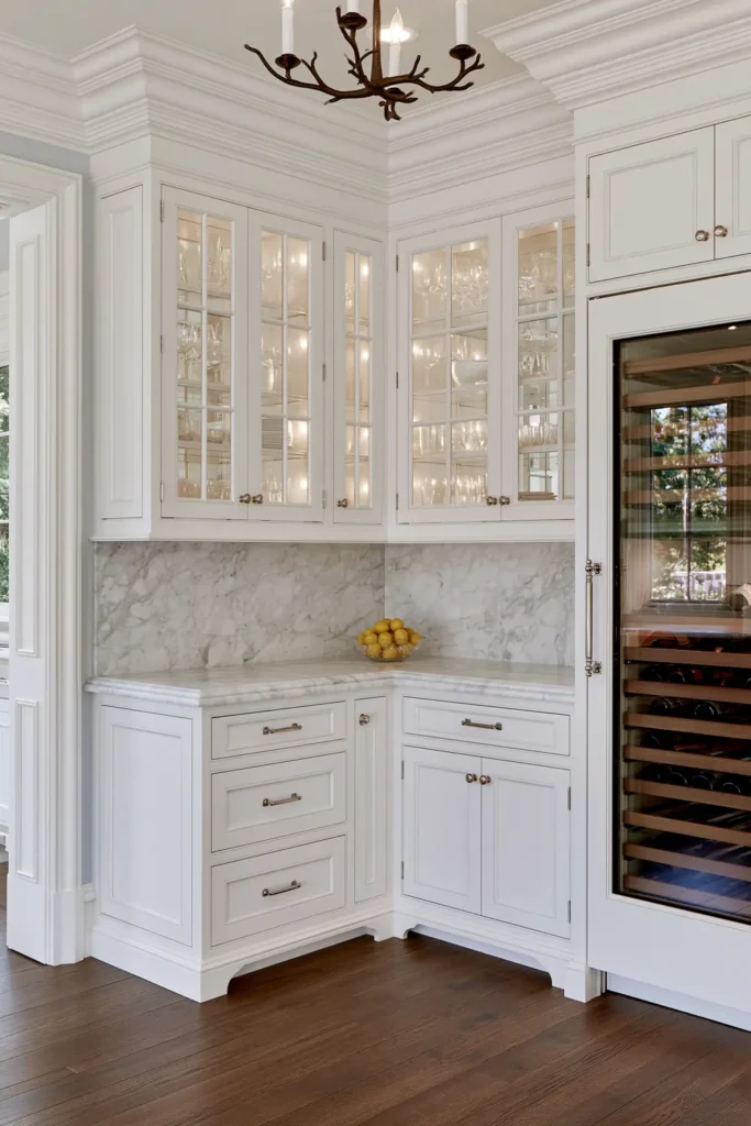 Timeless vs. Trendy Home Decor: 20 Ideas for a Well-Proportioned, Beautiful Home 4 Compact white kitchen with inset-panel cabinets, glass-front uppers, marble counters, dark wood floors, and a built-in wine refrigerator.