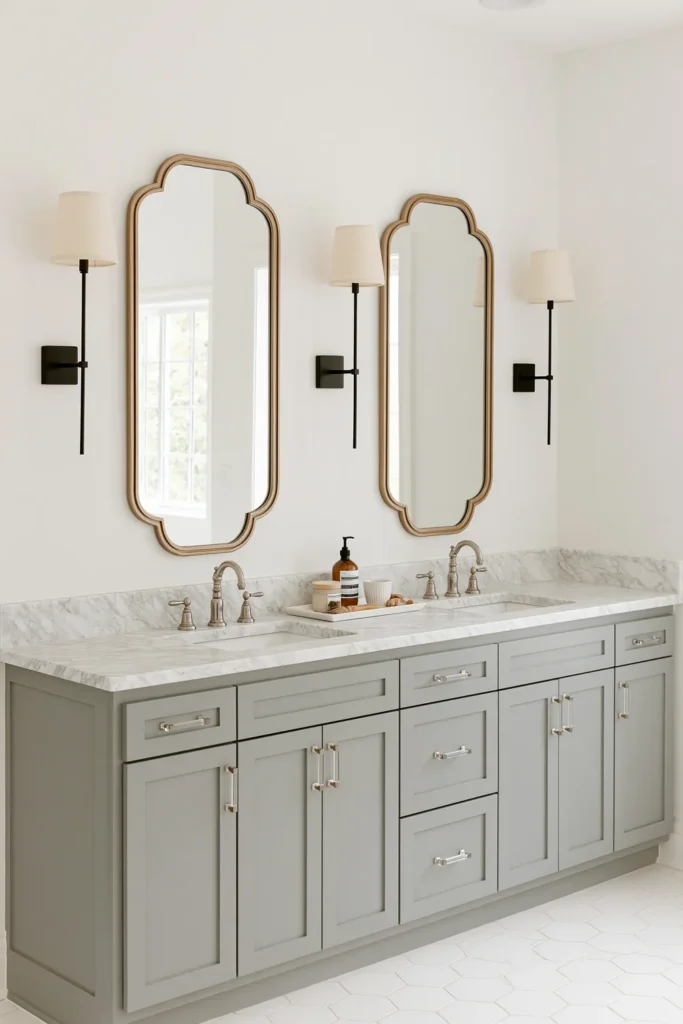 21 Guest Bathroom Decorating Ideas for a Friendly Space 3 Pale gray-lilac double vanity with a marble countertop, scalloped gold mirrors, and black wall sconces.