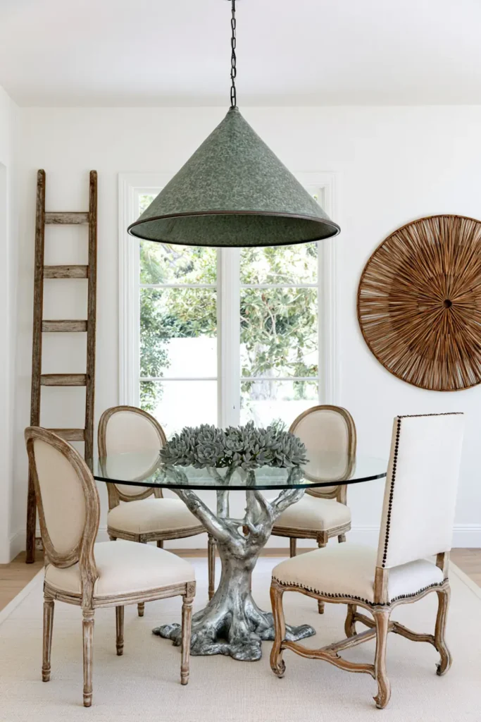 9 Mix and Match Dining Chair Ideas for a Stylish, Collected Look 4 Vintage dining chairs in different shapes with matching pale beige upholstery around a round glass dining table.