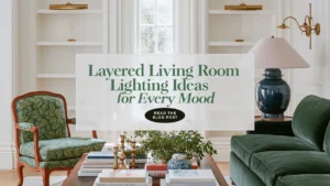 Traditional living room with a deep green velvet sofa, layered brass wall lighting, a blue ceramic table lamp, built-in bookcases, and a styled dark wood coffee table.