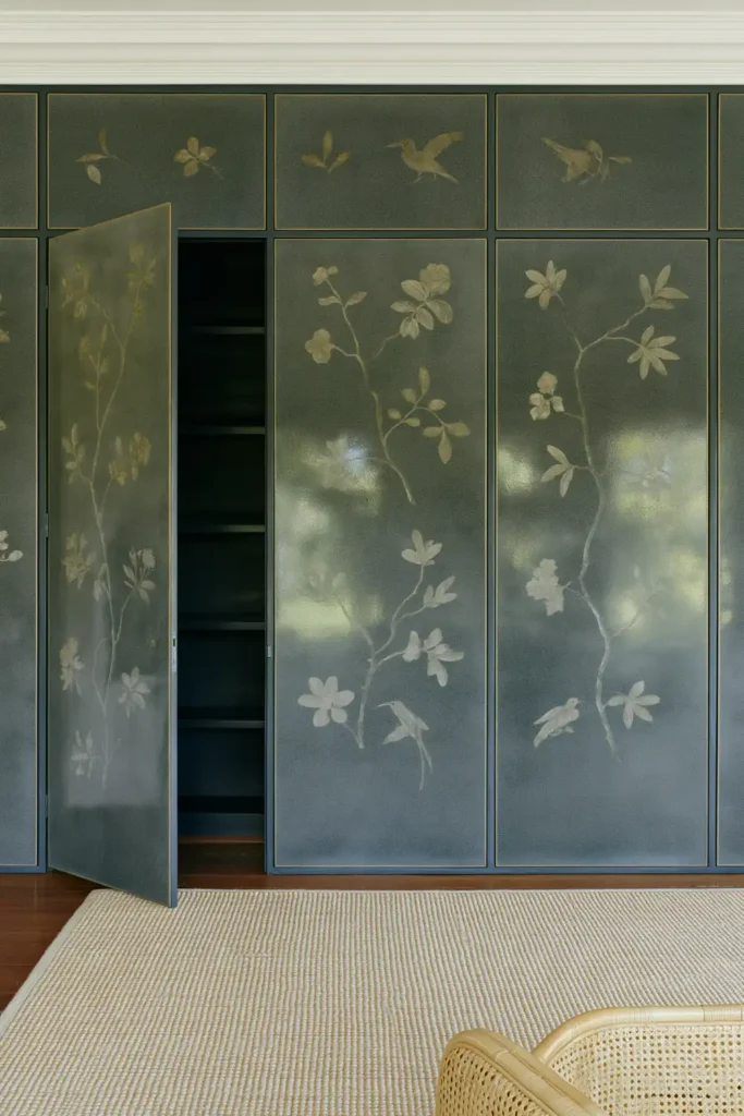 18 Secret Door Ideas That Fit Beautifully Into Your Home 16 Dark charcoal botanical secret door with silver-gray branches, a beige sisal rug, and pale woven seating.