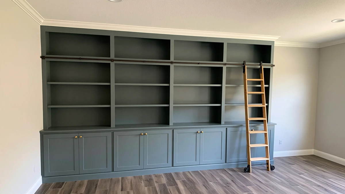 DIY IKEA Billy Bookcase Library Wall Ideas for a Custom Built-In Look 1 Teal DIY IKEA Billy bookcase library wall with Shaker cabinet doors, brass knobs, crown moulding, and a natural wood rolling ladder.