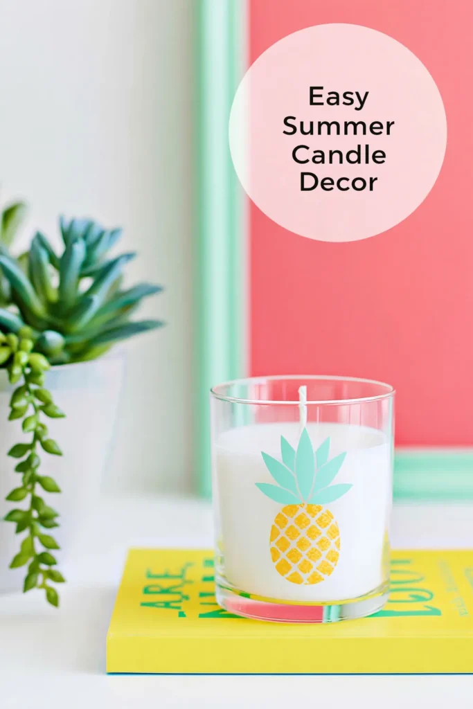 Tropical summer candle decor featuring a white candle in a clear glass holder with a turquoise and yellow pineapple illustration beside trailing succulents.