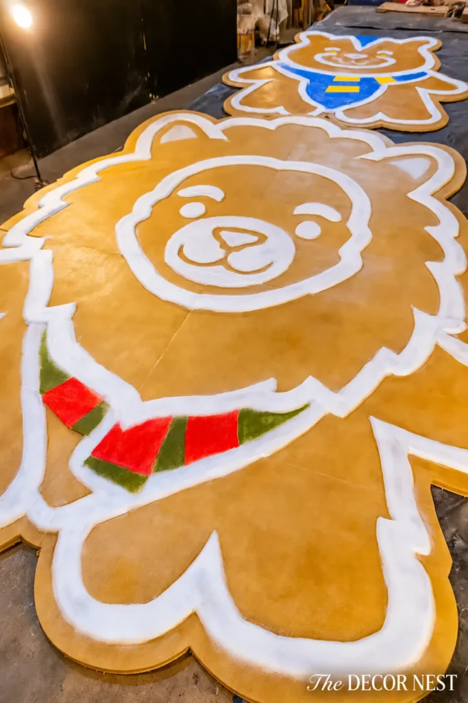 Oversized brown animal-shaped gingerbread cookie decorations with white icing outlines and colorful red, green, blue, and yellow scarf details.